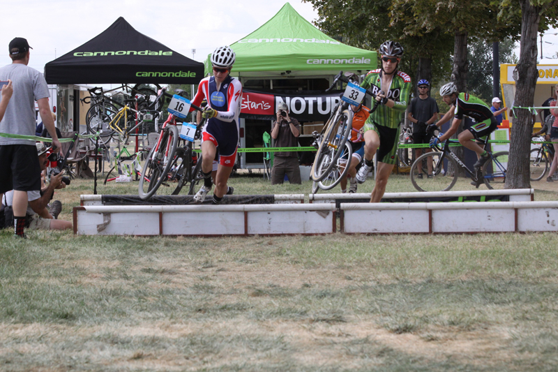 Keegan Swenson and Tyler Wren fly over the barriers at the Utah State Fairpark in the 2011 Utah Cyclocross Series race #2.