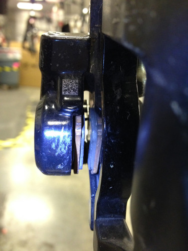Inspect the disc brake pads with a flashlight.