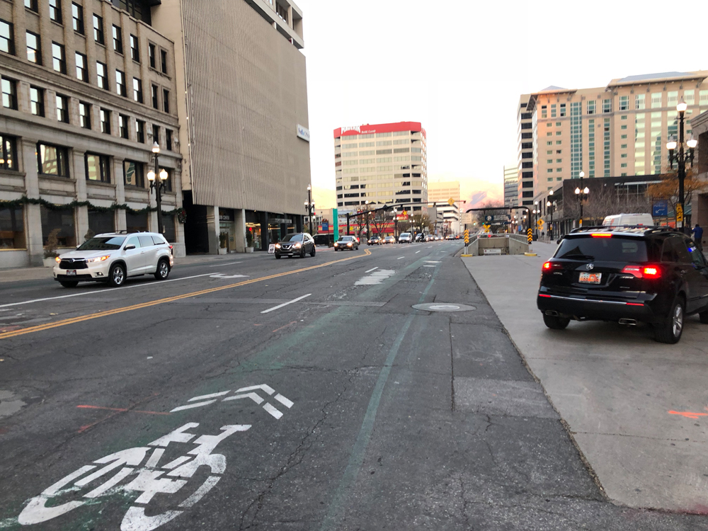 The green lane is almost gone on the south side of the street too. 200 S in Salt Lake City between State and Main has deteriorated and needs a protected bike lane on the south side (right of photo) by the Gallivan Center. Photo by Dave Iltis, Cycling Utah