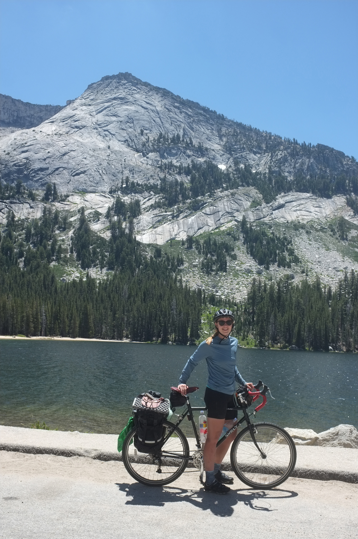 With a light pack on her final day of riding, Clara Hatcher pauses for a break next to Tenaya Lake after biking through Tuolumne Meadows. Photo by Rain Felkl